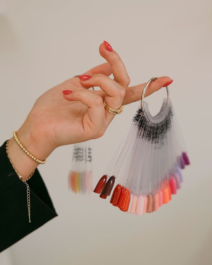 Hand holding rings of nail polish color swatches
